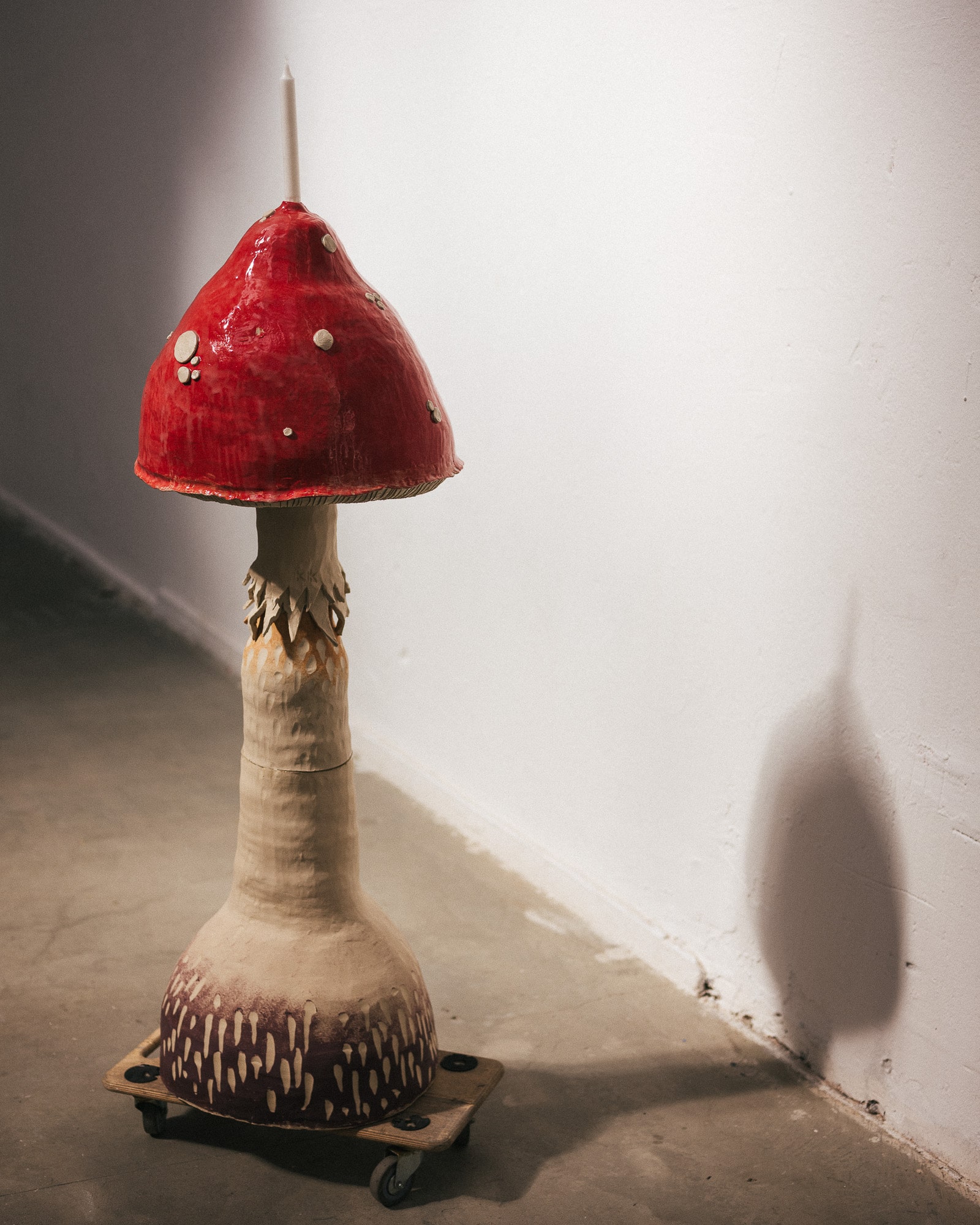 A ceramic candle holder in a shape of a huge, human sized red mushroom